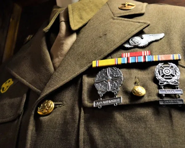 Primer plano de detalles de uniforme: galones, botones, insignias metálicas